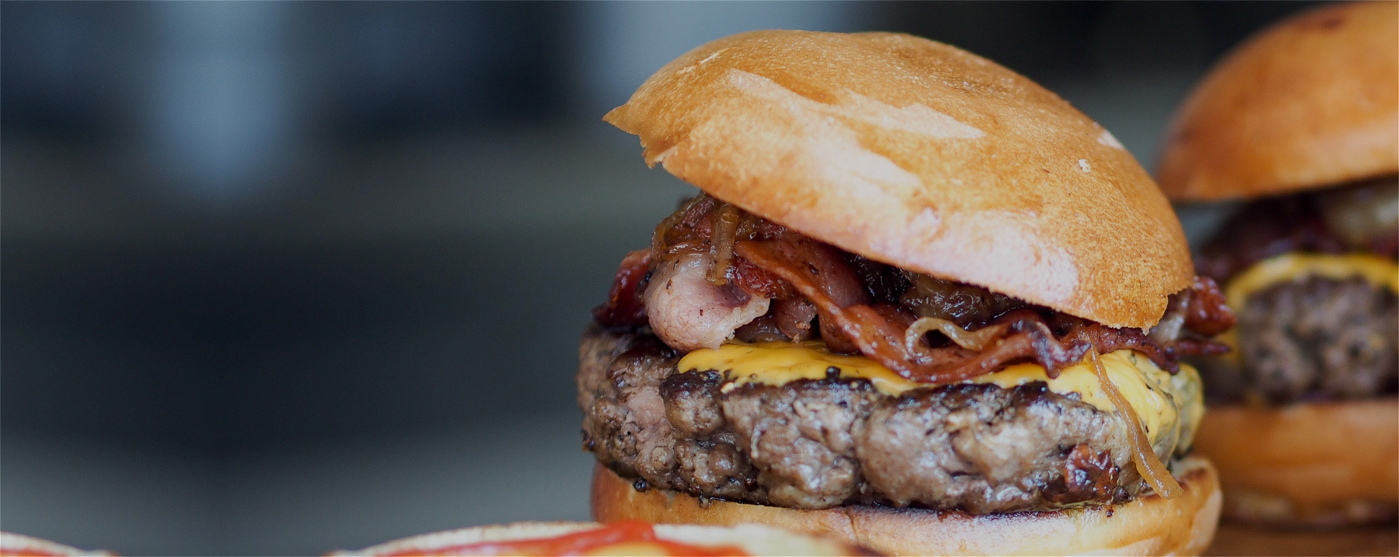 Primer plano de hamburguesa con bacon y cheddar fundido